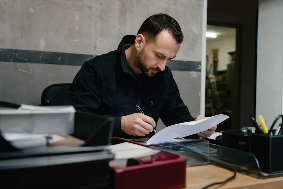 Kalendarz na biurku obok faktury z zaznaczonym terminem płatności